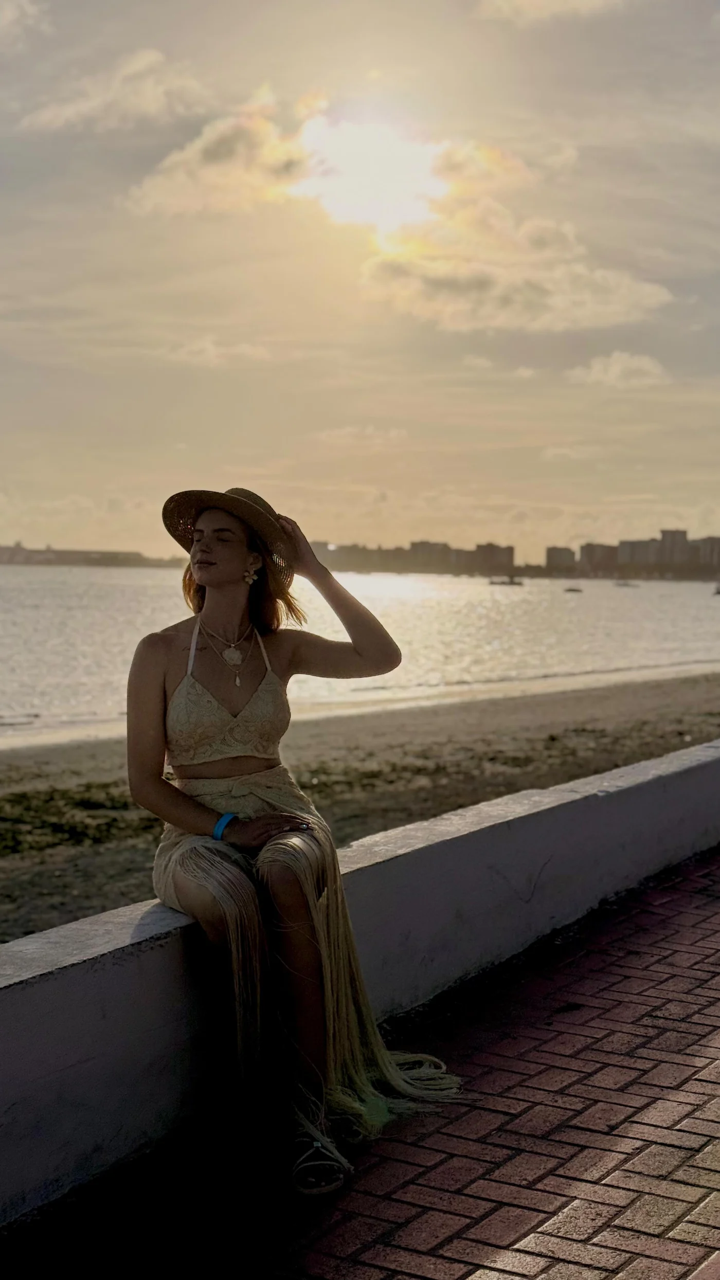 Alice Becker em cenário de viagem à beira-mar
